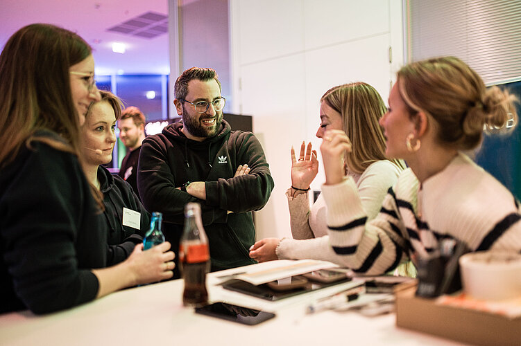 Start-up Szene NRW Eine Gruppe von Menschen unterhält sich.
