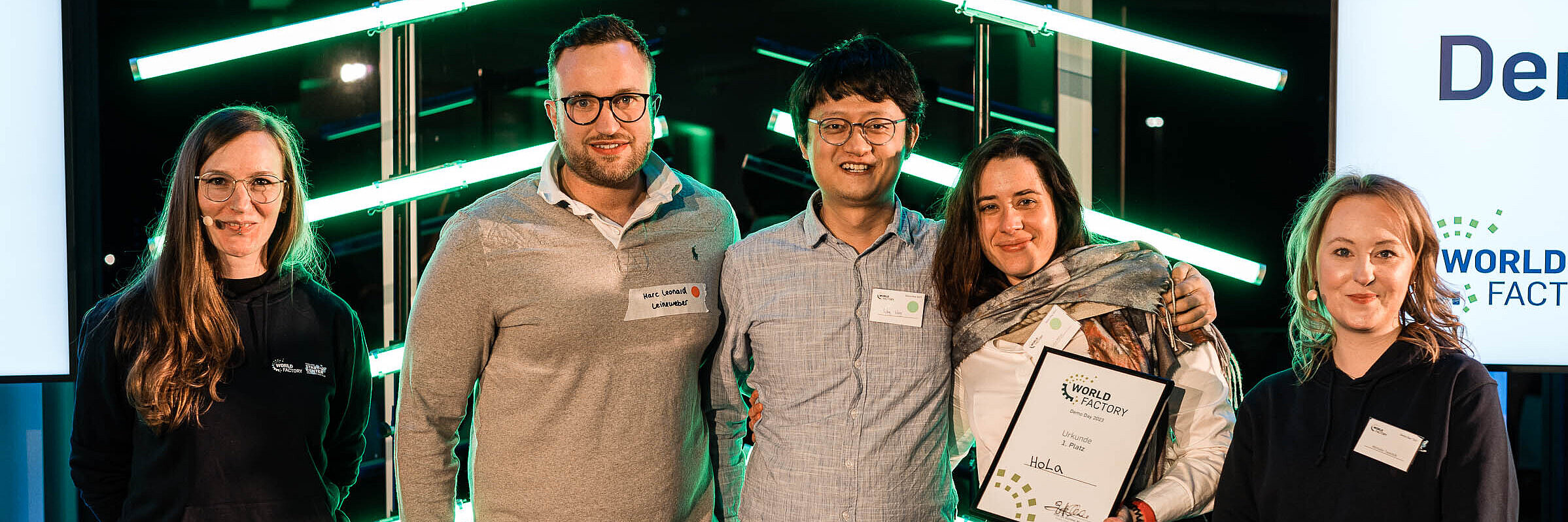 The top 5 start-ups of the RUB 2023 HoLa's team wins first place at WSC Demo Day 2023, standing next to WSC presenters Melusine Reimers and Michelle Twardzik.
